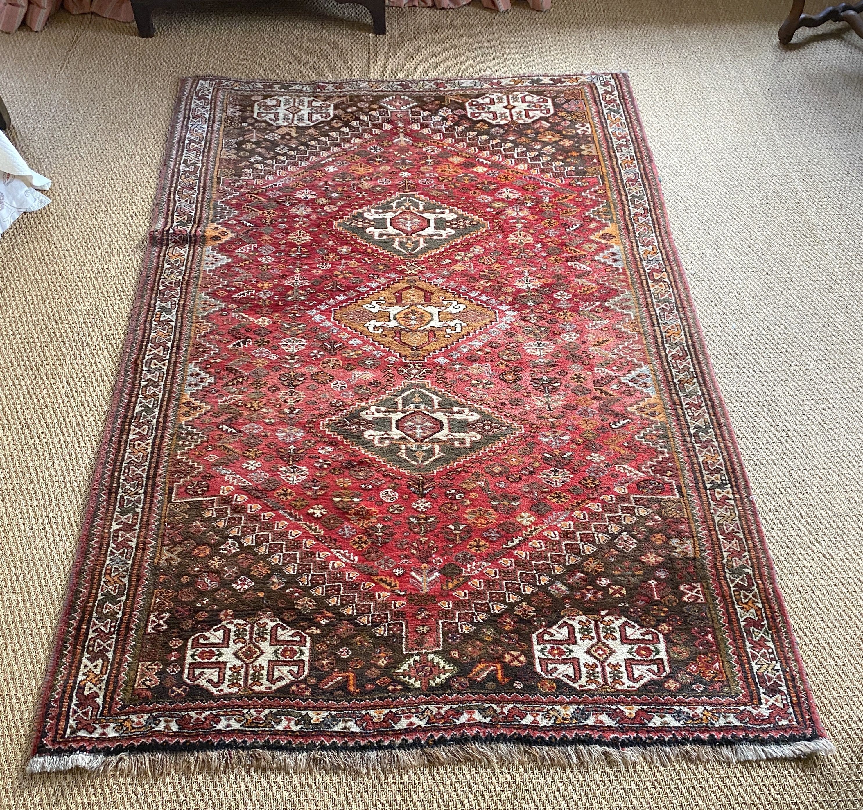 A Persian red ground rug, with three central hectagons and floral borders, 236 x 161cm